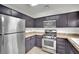 Well-lit kitchen featuring stainless steel appliances and dark cabinetry with ample storage space at 3891 Terrazzo Ave, Las Vegas, NV 89115