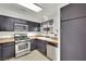 Well-lit kitchen featuring stainless steel appliances, dark cabinets and a large window, creating a pleasant cooking experience at 3891 Terrazzo Ave, Las Vegas, NV 89115