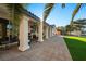 A paver patio with columns offers outdoor living space and views of the well maintained yard with artificial turf at 5130 Agio Ave, Pahrump, NV 89061