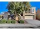 Two-story house with stone accents, landscaped yard, and a two-car garage at 7032 N Albatross Attic St, North Las Vegas, NV 89084