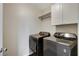 Convenient laundry room with washer, dryer, and overhead cabinets at 7032 N Albatross Attic St, North Las Vegas, NV 89084