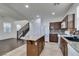 Modern kitchen with granite island, dark cabinets and tile floor at 7640 Houston Peak St, Las Vegas, NV 89166