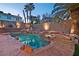 Backyard pool and spa area with a rock waterfall feature and tropical landscaping at 8940 Sailplane Ave, Las Vegas, NV 89129