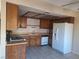 Kitchen with wood cabinetry, gas range, and white appliances at 6653 W Tropicana Ave # 101, Las Vegas, NV 89103