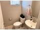 Small half bathroom with a pedestal sink and toilet at 10766 Wild Parsley Ave, Las Vegas, NV 89129