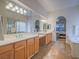 Bathroom with double sinks, large mirrors, and a view of the bedroom at 10840 Villa Torre St, Las Vegas, NV 89141