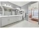 Elegant bathroom with double vanity, white cabinets, and a view of the bedroom at 1170 N Water St, Henderson, NV 89011