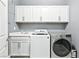 Bright laundry room with white cabinets, washer, and dryer at 1170 N Water St, Henderson, NV 89011