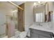 Bathroom with gray vanity, gold fixtures, and a walk-in shower at 1343 Panini Dr, Henderson, NV 89052