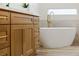 Modern bathroom with freestanding bathtub and wood cabinets at 1343 Panini Dr, Henderson, NV 89052