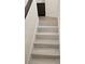 Modern staircase with light gray tile and dark brown cabinetry at 1732 Monte Alban Dr, North Las Vegas, NV 89031