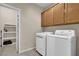 Bright laundry room, washer, dryer, cabinets, and extra shelving at 2067 Bliss Corner St, Henderson, NV 89044