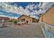 View of home's rear exterior highlighting its covered patio and low maintenance gravel landscaping at 2221 E Winery Rd, Pahrump, NV 89048