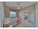 Bedroom with a ceiling fan, window, and mirrored closet at 2221 E Winery Rd, Pahrump, NV 89048