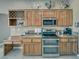 Well-equipped kitchen featuring wood cabinets, granite countertops, and modern stainless steel appliances at 2221 E Winery Rd, Pahrump, NV 89048