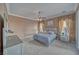 Serene main bedroom with crown molding, ceiling fan, and a large window overlooking backyard views at 2221 E Winery Rd, Pahrump, NV 89048