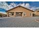 This is the rear exterior featuring a covered patio and low-maintenance gravel landscaping at 2221 E Winery Rd, Pahrump, NV 89048