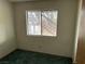 Small bedroom with teal carpet and window at 3160 James A Bilbray Pkwy, Laughlin, NV 89029