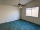 Bedroom with teal carpet, ceiling fan, and large window at 3160 James A Bilbray Pkwy, Laughlin, NV 89029