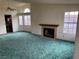 Living room with a fireplace and teal carpet at 3160 James A Bilbray Pkwy, Laughlin, NV 89029