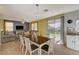 Bright dining area with a wood table and white chairs, adjacent to the living room and kitchen at 3517 Colby Creek Ave, North Las Vegas, NV 89081