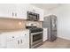 This kitchen features stainless steel appliances, white cabinets, and light countertops at 3517 Colby Creek Ave, North Las Vegas, NV 89081