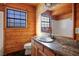 Clean bathroom with wood walls, granite countertop, and a large mirror at 3900 W Landberg Ave, Las Vegas, NV 89141