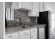 Kitchen with granite countertops, white cabinets, and double sink at 3939 Springhill Ave, Las Vegas, NV 89121