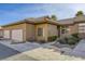 Tan stucco house with tile roof, attached garage, and landscaped walkway at 4773 Big Draw Dr, North Las Vegas, NV 89031