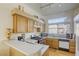 Galley kitchen with light wood cabinets, gas stove, and built-in microwave at 4773 Big Draw Dr, North Las Vegas, NV 89031