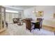 Open living and dining area with brown leather furniture and glass-top table at 4773 Big Draw Dr, North Las Vegas, NV 89031