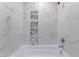 Clean bathroom with a white bathtub and marble-style tile at 4825 Greencreek Dr, Las Vegas, NV 89110