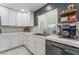 Modern kitchen with white shaker cabinets, stainless steel appliances, and herringbone backsplash at 4825 Greencreek Dr, Las Vegas, NV 89110