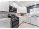 Modern kitchen with white cabinets, stainless steel appliances, and quartz countertops at 4825 Greencreek Dr, Las Vegas, NV 89110