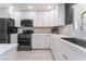 Modern kitchen with white cabinets, stainless steel appliances, and quartz countertops at 4825 Greencreek Dr, Las Vegas, NV 89110