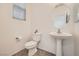 Clean powder room with pedestal sink, toilet, and window at 4944 Guysborough St, Las Vegas, NV 89148