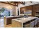 Spacious kitchen with double island, stone countertops, and exposed wooden beams at 5 Promontory Pointe Ln, Las Vegas, NV 89135