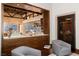 Wine cellar with glass door, gray armchairs, and view into adjacent sitting area at 5 Promontory Pointe Ln, Las Vegas, NV 89135