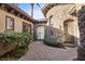 Charming courtyard entrance with stone accents, wrought iron gate, and lush landscaping, creating a welcoming entry at 51 Avenida Sorrento, Henderson, NV 89011