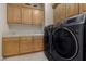 Modern laundry room with black front load machines, cabinets and tile countertops at 51 Avenida Sorrento, Henderson, NV 89011