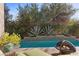 Inviting pool area featuring a fire pit, lush landscaping, and a tranquil water feature with succulents at 51 Avenida Sorrento, Henderson, NV 89011