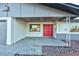 Red front door entrance with covered porch and rock landscaping at 5153 Woodruff Pl, Las Vegas, NV 89120