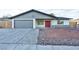 Newly renovated home with gray garage door and red front door at 5153 Woodruff Pl, Las Vegas, NV 89120