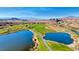 Expansive aerial view of a golf course community with lake, green space, and mountain views at 6 Lilla Rosa St, Henderson, NV 89011