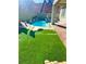 Green backyard featuring artificial grass, modern lounge chairs, and a small splash pool at 6 Lilla Rosa St, Henderson, NV 89011