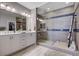 Bathroom featuring a double vanity sink, shower with glass door, and towel ladder at 6 Lilla Rosa St, Henderson, NV 89011