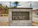 Stone community sign for Alta Fiore, surrounded by landscaped rocks, bushes, and other greenery at 6 Lilla Rosa St, Henderson, NV 89011