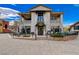 Two-story commercial building with a stucco exterior, black awning, and outdoor seating at 6 Lilla Rosa St, Henderson, NV 89011