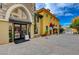 Attractive storefront with large arched windows and inviting 'We're Open' sign on a sunny, paved street at 6 Lilla Rosa St, Henderson, NV 89011