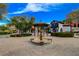 A fountain sits centerstage on a brick-paved roundabout with retail buildings in the background at 6 Lilla Rosa St, Henderson, NV 89011